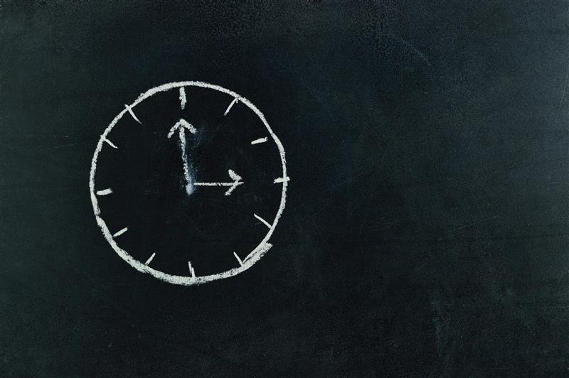 Reloj dibujado en pizarra representando las leyes laborales en España